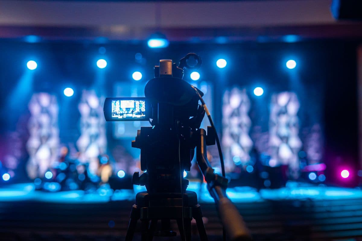 A production team filming a live performance from the audience